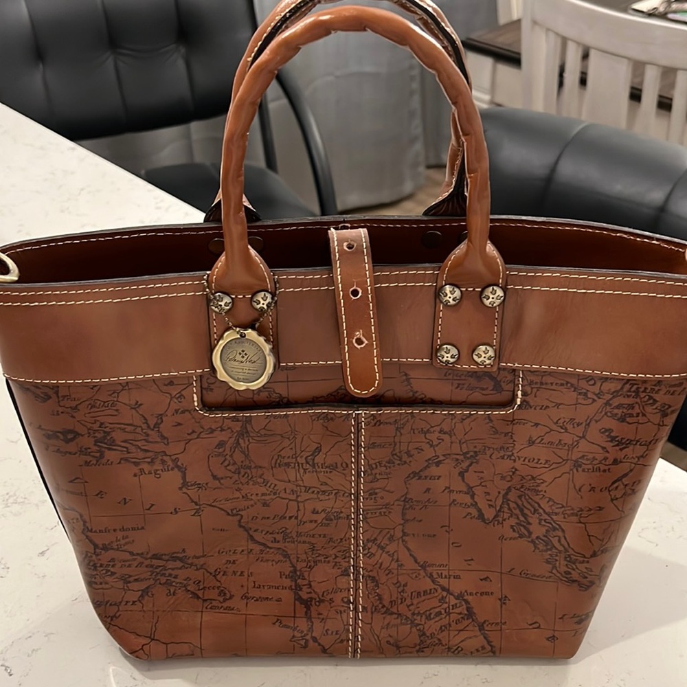 Never used, map print. Has registration card, crossbody strap and dust bag